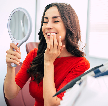 A woman smiling at a mirror