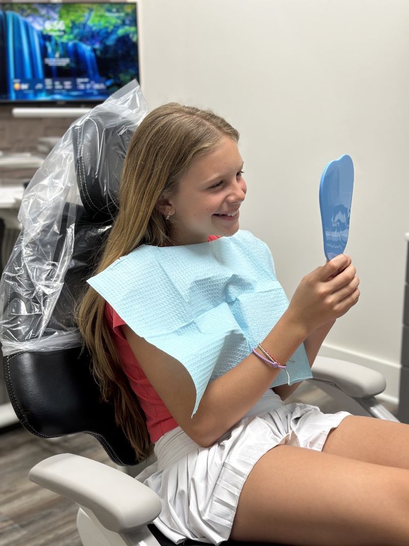 Child smiling after dental treatment—illustrating family dentistry excellence at Moore Dental Arts.