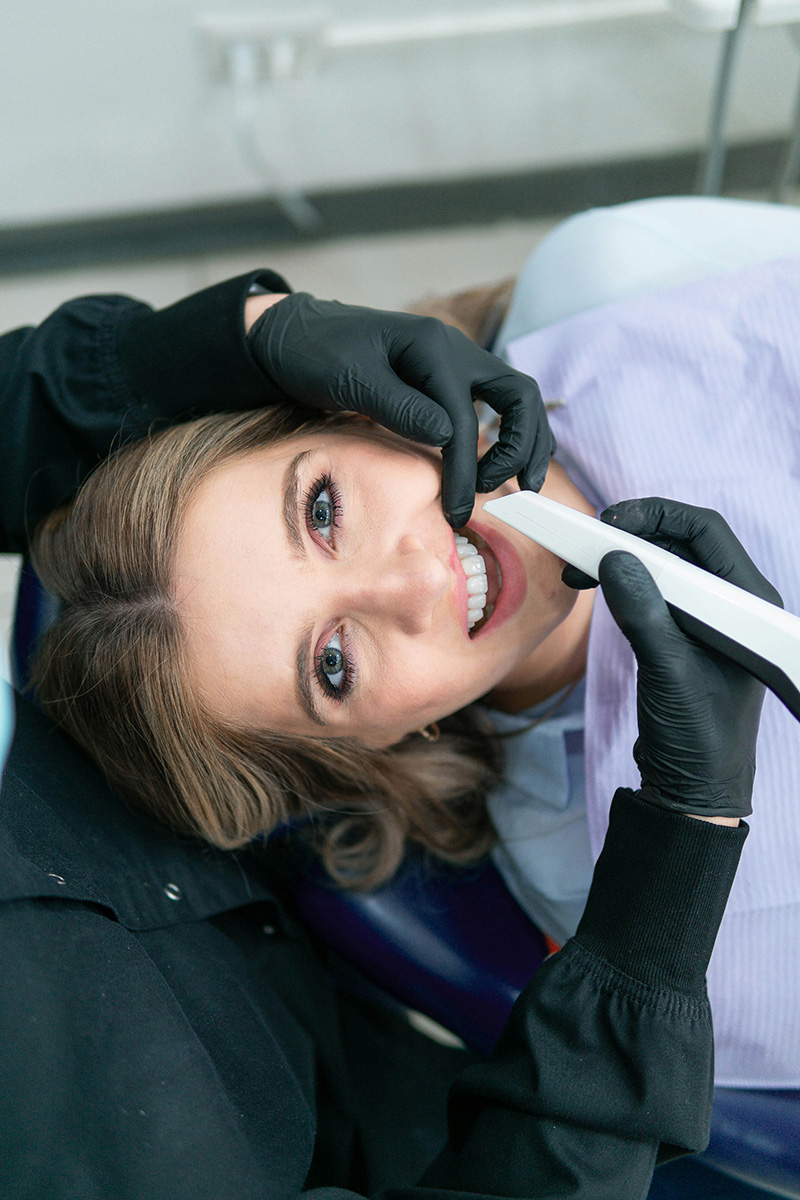 A patient smiles while having a smile makeover procedure done