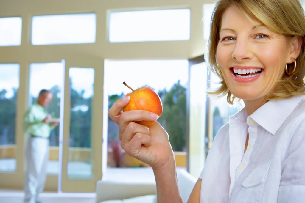 Woman who searched "dental implants near you" showing off her new smile.
